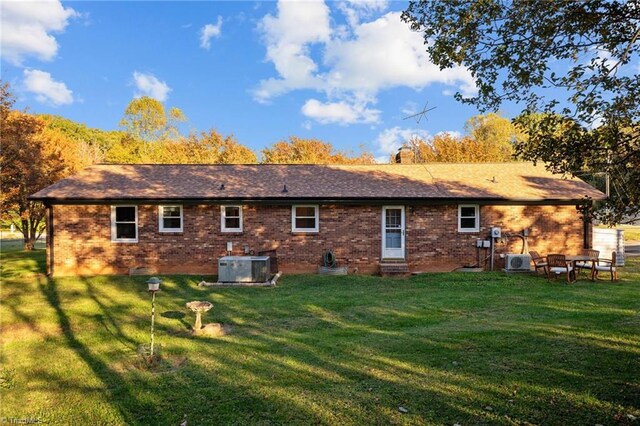 back of property featuring a yard and cooling unit