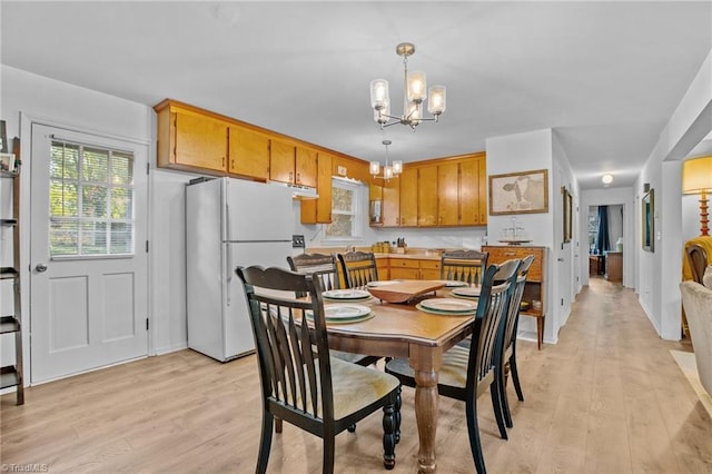 dining space featuring a notable chandelier and light hardwood / wood-style flooring