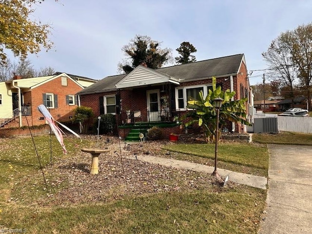 view of front of house with a front lawn and central AC unit