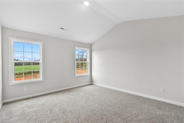 carpeted spare room featuring lofted ceiling