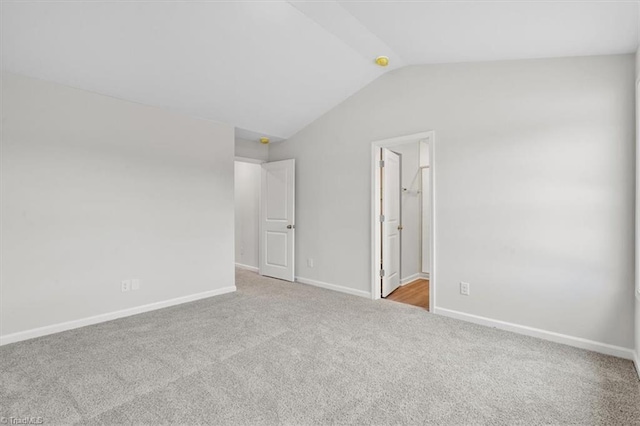 empty room with light carpet and vaulted ceiling