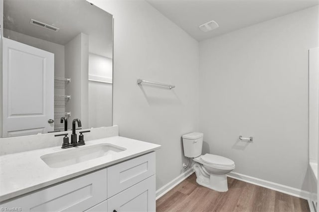 bathroom featuring hardwood / wood-style flooring, vanity, and toilet