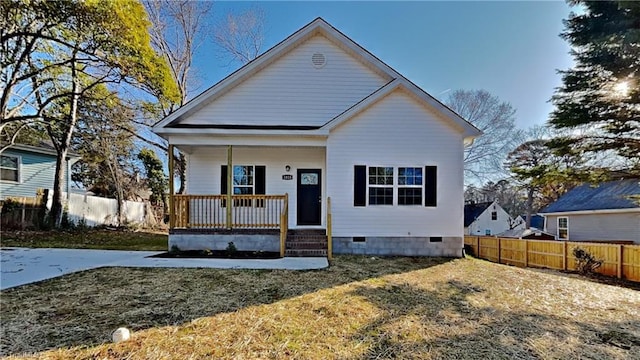 bungalow-style house with covered porch, a front lawn, crawl space, and fence