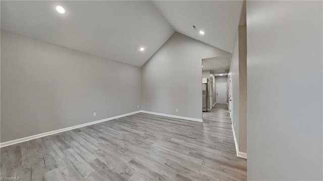 empty room featuring light wood-style floors, lofted ceiling, baseboards, and recessed lighting