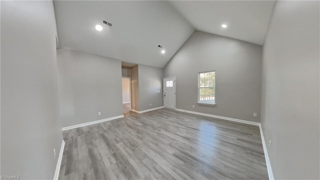 unfurnished room with high vaulted ceiling, recessed lighting, visible vents, baseboards, and light wood-type flooring