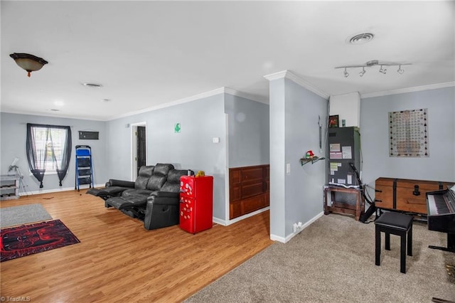 living room featuring baseboards, ornamental molding, and wood finished floors