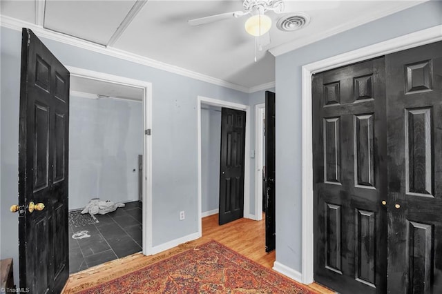 bedroom with crown molding, baseboards, a ceiling fan, and wood finished floors
