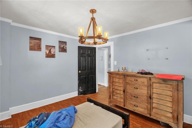 bedroom with a chandelier, crown molding, wood finished floors, and baseboards