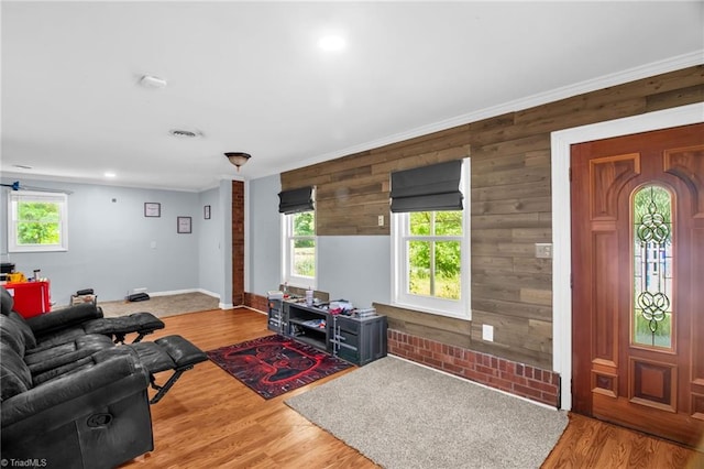 living room featuring wood walls, wood finished floors, baseboards, and recessed lighting