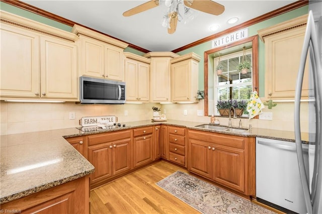 kitchen featuring light stone counters, ornamental molding, stainless steel appliances, sink, and light hardwood / wood-style floors