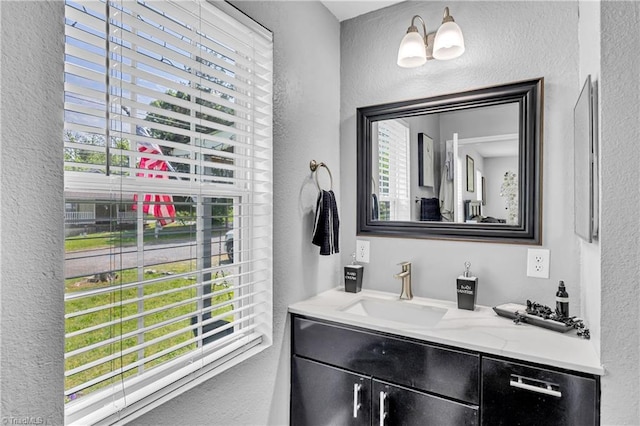 bathroom with plenty of natural light, vanity, and a textured wall
