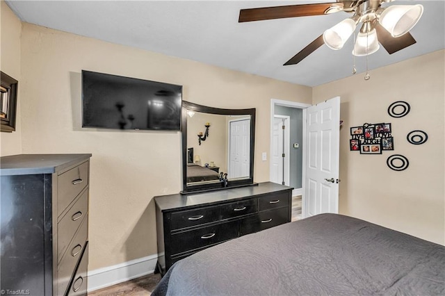 bedroom featuring baseboards, ceiling fan, and wood finished floors