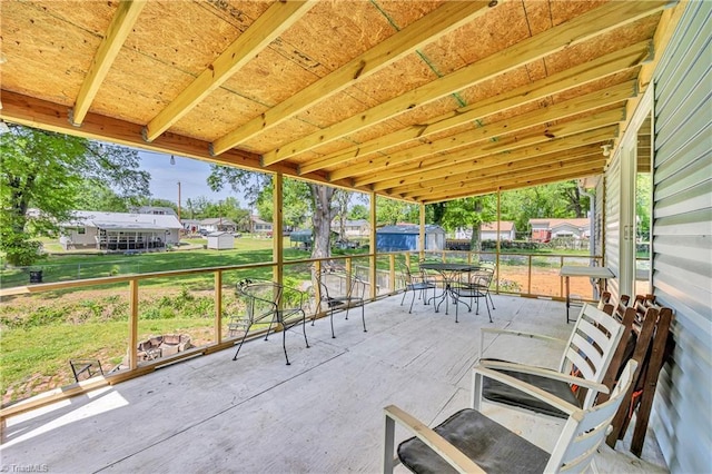 view of patio featuring fence, an outbuilding, a shed, and outdoor dining space