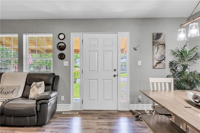 entryway with a healthy amount of sunlight, baseboards, and wood finished floors