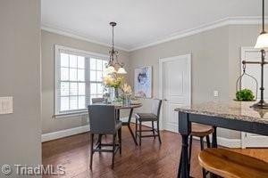 dining room featuring crown molding and dark hardwood / wood-style floors