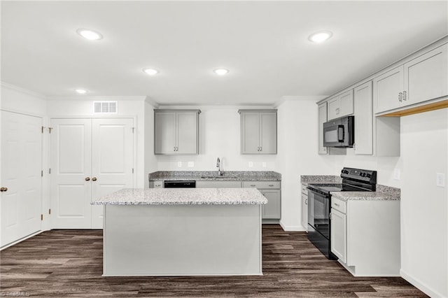 kitchen featuring dark wood-style floors, visible vents, a sink, and black appliances