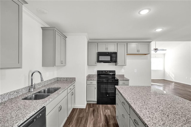 kitchen featuring black appliances, dark wood-style floors, gray cabinets, and a sink