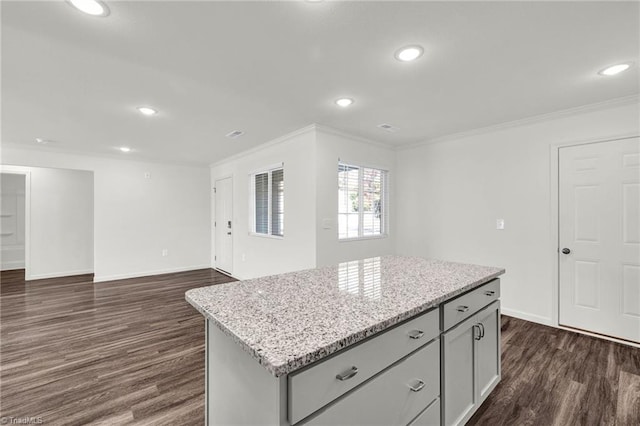 kitchen featuring baseboards, ornamental molding, dark wood finished floors, and a center island