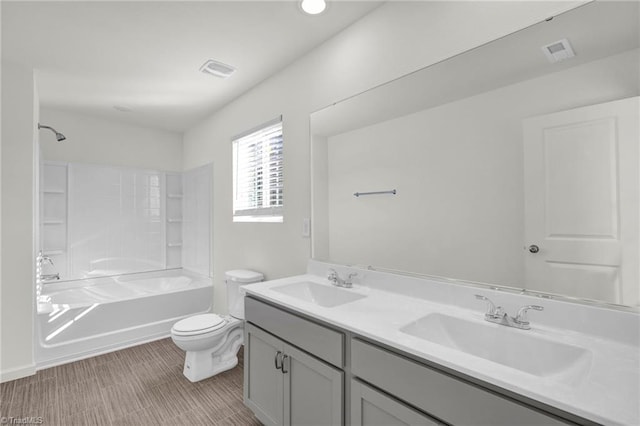 full bath with visible vents, washtub / shower combination, a sink, and toilet