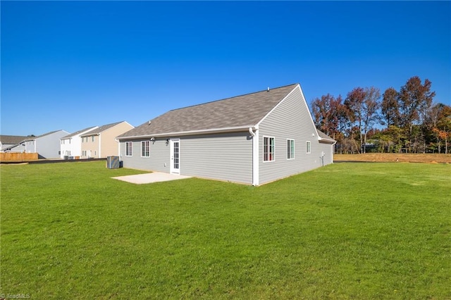 view of side of home with a patio and a lawn