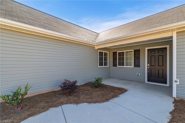 entrance to property with roof with shingles