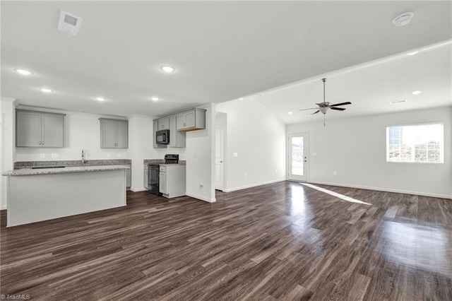 kitchen featuring recessed lighting, baseboards, gray cabinets, black appliances, and dark wood finished floors