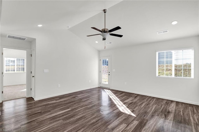 unfurnished room with dark wood-type flooring, a wealth of natural light, visible vents, and vaulted ceiling