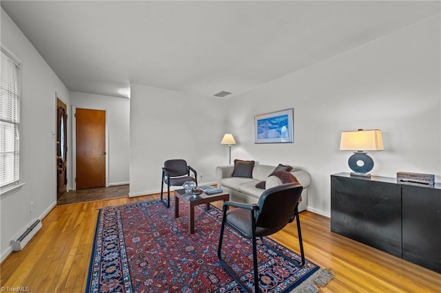 living room featuring wood-type flooring and a baseboard radiator