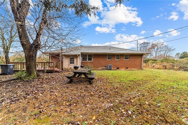 back of house with cooling unit, a deck, and a yard