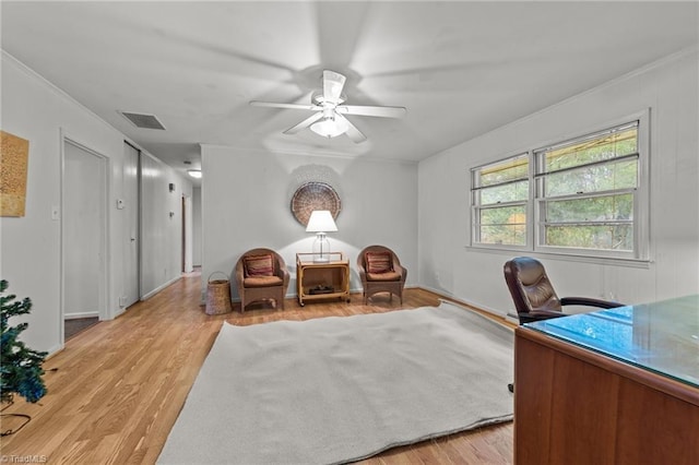 home office with ceiling fan, light wood-type flooring, and ornamental molding