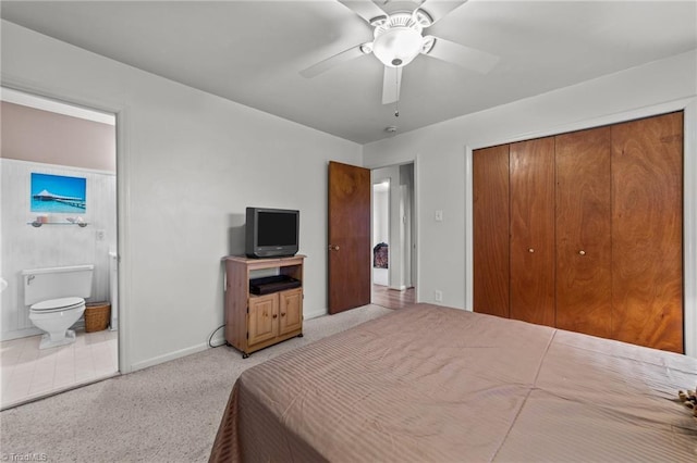 bedroom with connected bathroom, ceiling fan, a closet, and light carpet