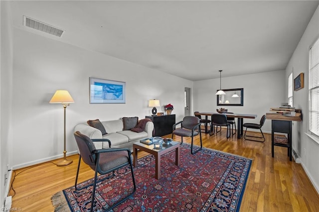 living room featuring hardwood / wood-style flooring and a baseboard heating unit