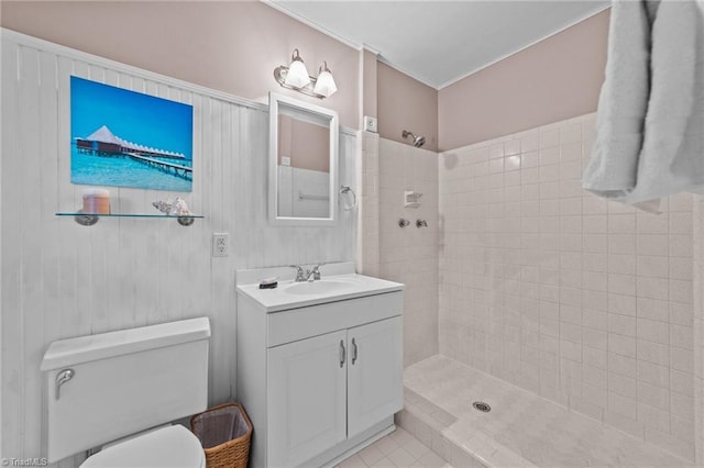 bathroom with a tile shower, tile patterned flooring, vanity, and toilet