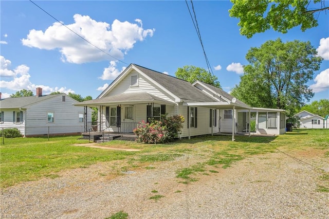 rear view of house featuring a yard and a porch