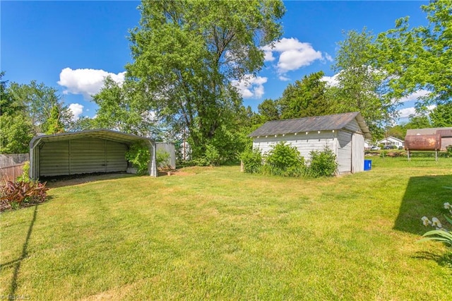 view of yard with a carport and a storage shed