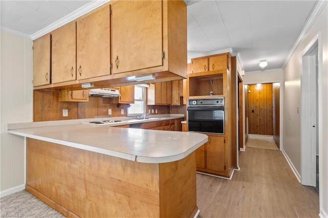 kitchen featuring light wood-type flooring, crown molding, kitchen peninsula, sink, and black oven