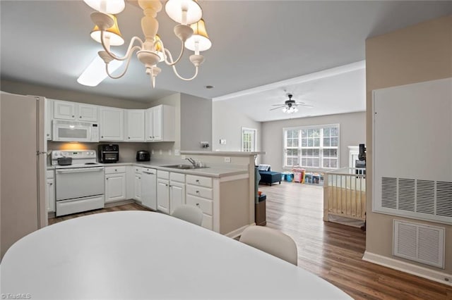 kitchen featuring a sink, white appliances, open floor plan, wood finished floors, and visible vents