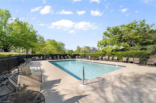 community pool with a patio and fence
