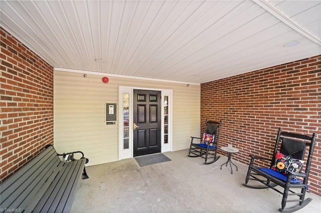 view of exterior entry featuring brick siding