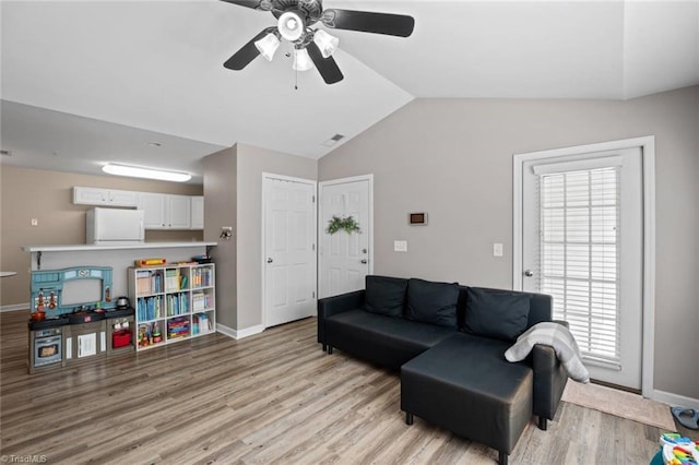 living room with light wood-style flooring, a ceiling fan, baseboards, lofted ceiling, and visible vents