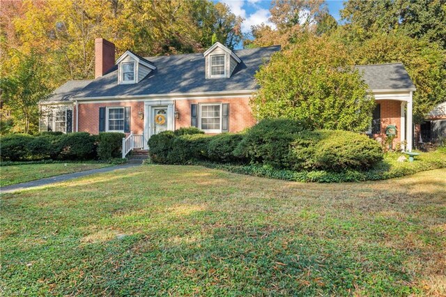 cape cod home featuring a front lawn