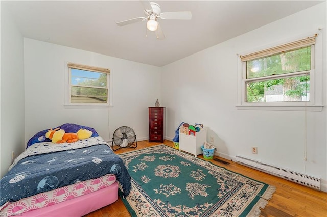 2003 Random Dr, Greensboro, NC 27407 - bedroom with a baseboard radiator, wood finished floors, ceiling fan, and baseboards