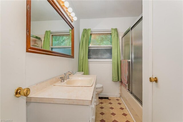 2003 Random Dr, Greensboro, NC 27407 - full bath featuring tile patterned floors, vanity, toilet, and bath / shower combo with glass door