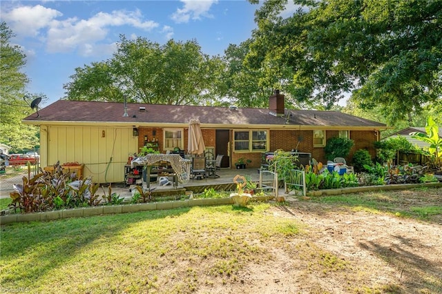 2003 Random Dr, Greensboro, NC 27407 - rear view of house with brick siding, a chimney, a patio area, and a yard
