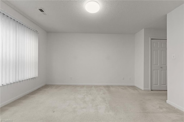 carpeted empty room with a textured ceiling