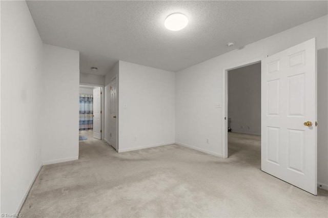 spare room with light carpet and a textured ceiling