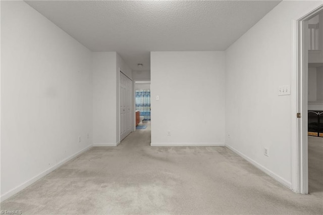 unfurnished room with light carpet and a textured ceiling