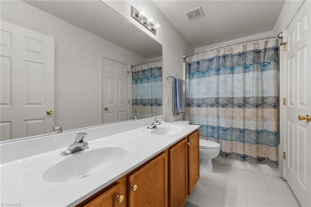 bathroom with vanity, toilet, and a textured ceiling