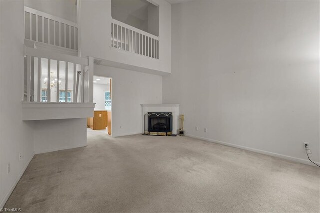 unfurnished living room with carpet and a towering ceiling