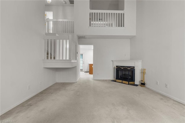 unfurnished living room featuring a towering ceiling and carpet floors